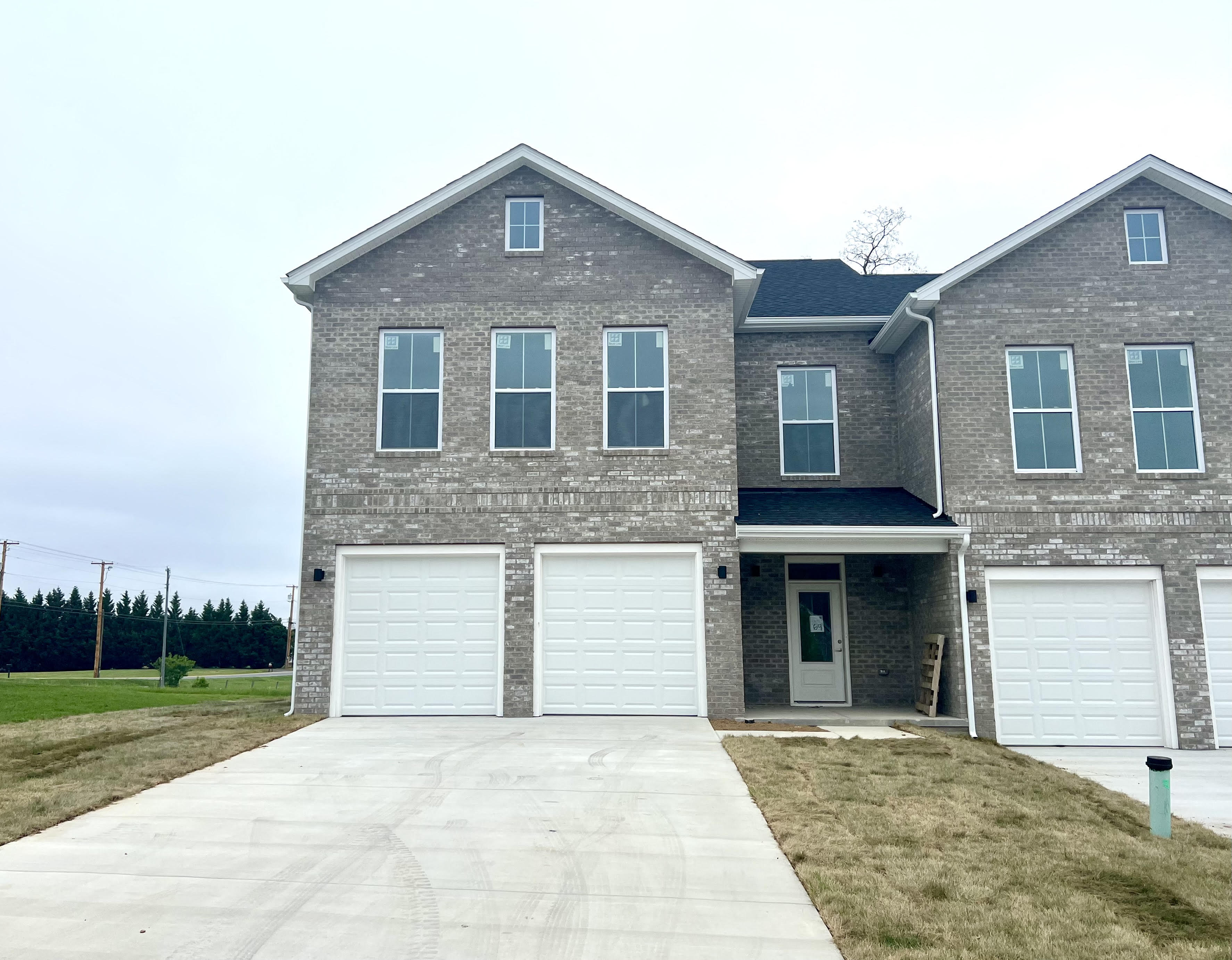 4 bedroom & 2.5 bath,a brick house with white garage doors and a driveway